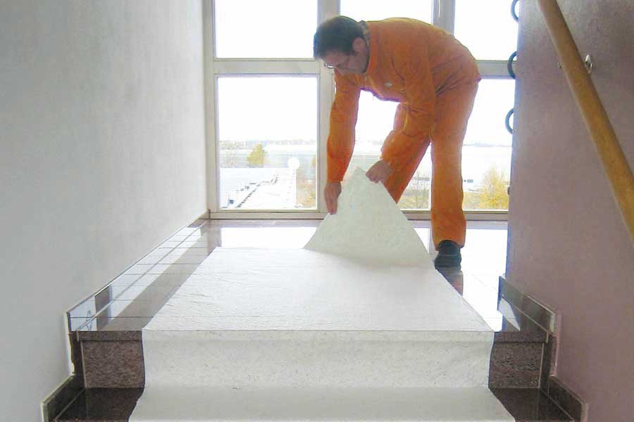 Handwerker verlegt Flies auf Treppe