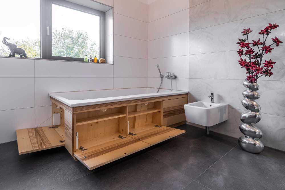 Betzl Haustechnik Referenzbad - individuell mit Stauraum umbaute Wanne - alle Klappen offen