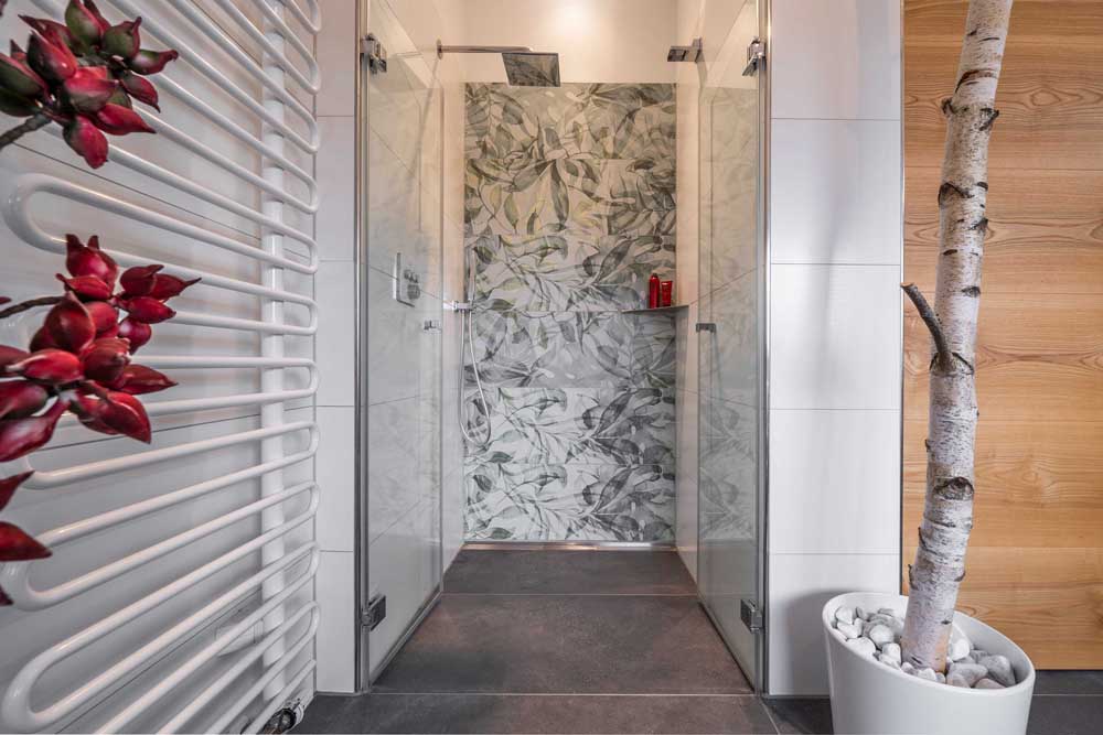 Betzl Haustechnik Referenzbad - Blick in die Dusche mit farbiger Rückwand