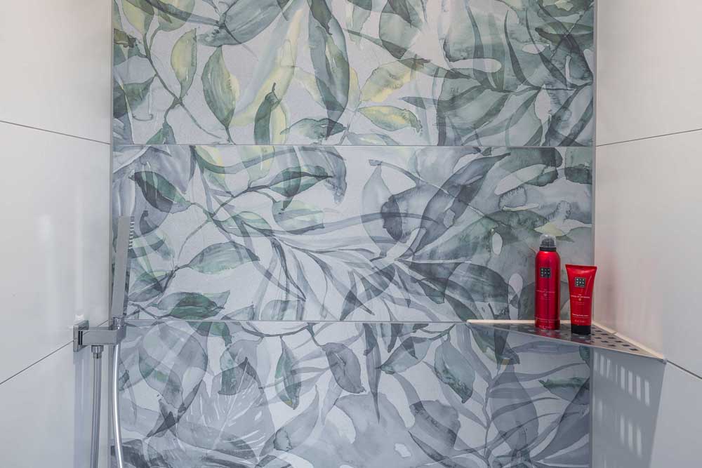 Betzl Haustechnik Referenzbad - Blick in die Dusche mit farbiger Rückwand close up