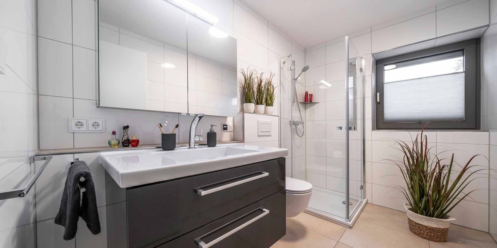 Betzl Haustechnik Referenz-Bad mit schwarzem Waschtisch, Spiegel, WC und Eckdusche